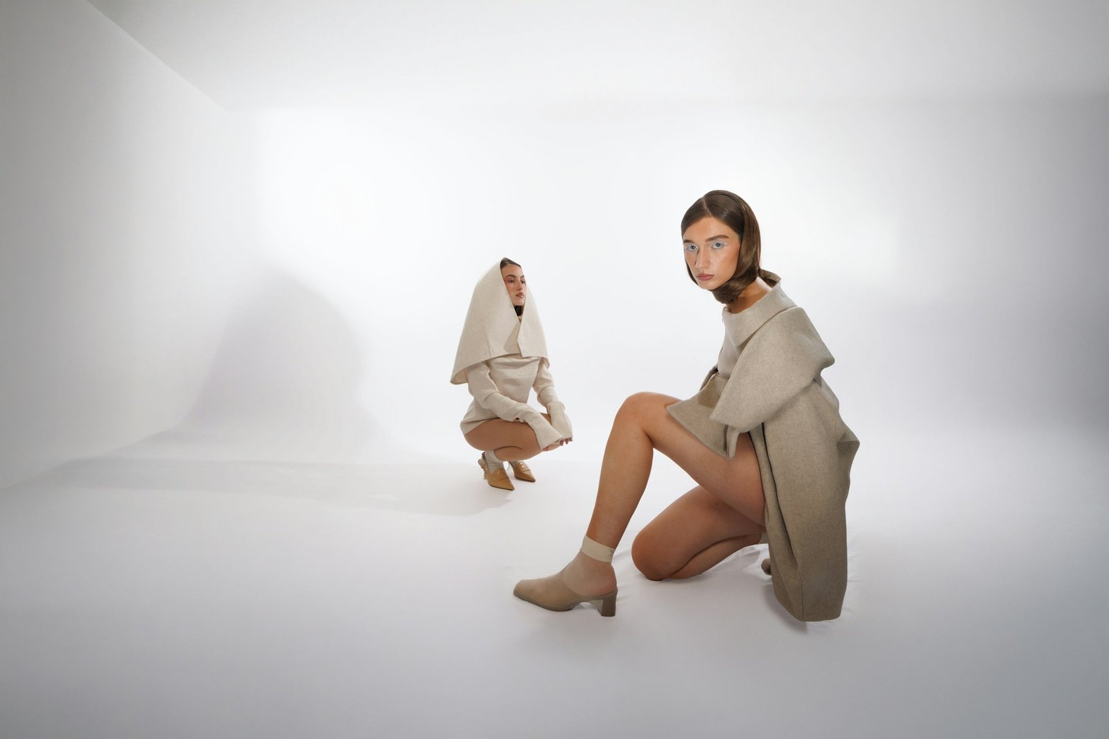 Dues models amb peces de tons neutres en un estudi de moda